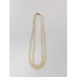 A double stranded vintage cultured pearl necklace with white metal push barrel clasp. Longest strand