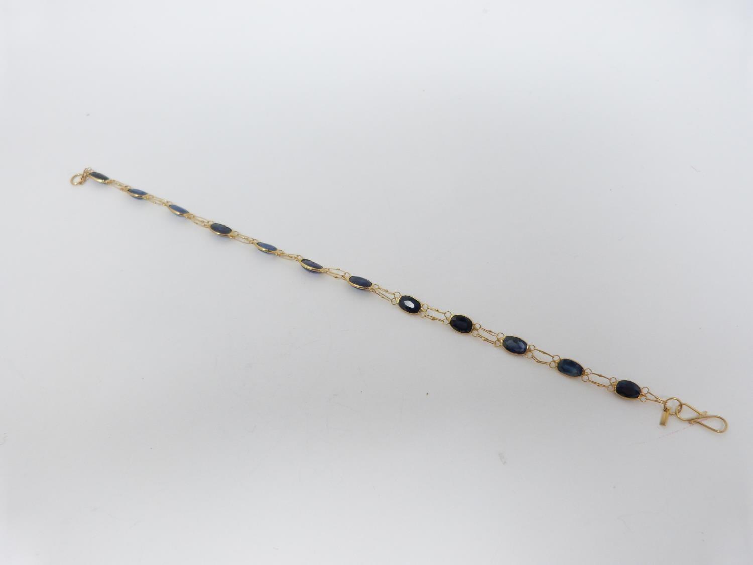 A bespoke heated ceylon sapphire and yellow metal (tested 14 carat yellow gold) chain bracelet, - Image 3 of 8