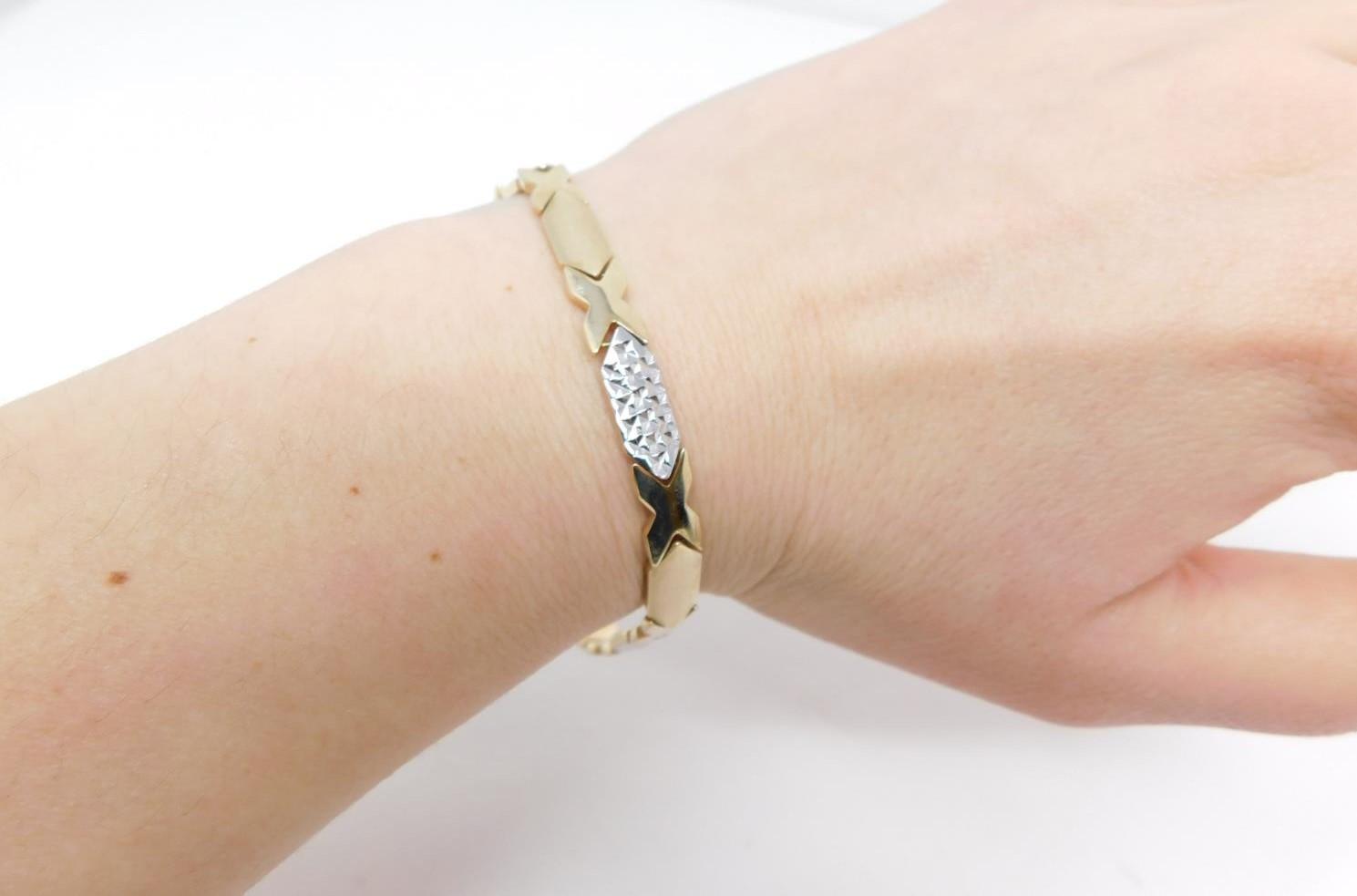 A 14 carat bi-colour gold articulated bracelet, with cross-hatched texture and X-shape design. - Image 10 of 10