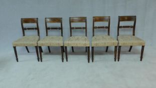 A set of five late Georgian mahogany and satinwood inlaid dining chairs in damask stuffover seats on