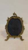 An antique Rococo style brass foliate and scrolling design two footed easel picture frame. With