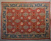A Kilim with repeating scrolling floral design surrounded by an azure stylised flowerhead border.