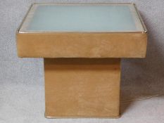 A glass topped pedestal coffee table with lift up opaque plate top, uplit and wired from beneath.