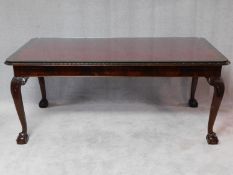 A mid Georgian style mahogany library table with inset tooled leather top on carved cabriole