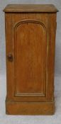 A Victorian pitch pine pot cupboard fitted with arched panel door on plinth base. H.74 W.35 D.35cm