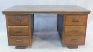 An Indian teak pedestal desk with planked top above six drawers and panelled ends on block feet. H.