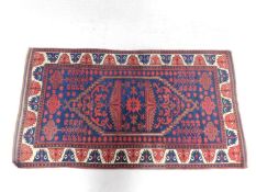 A Persian rug with central lozenge medallion and allover floral motifs on a sapphire ground