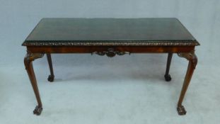 A Georgian style flame mahogany console table with plate glass top above carved frieze on cabriole