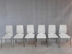 A set of six white painted laminated dining chairs on chrome tubular supports. H.86cm