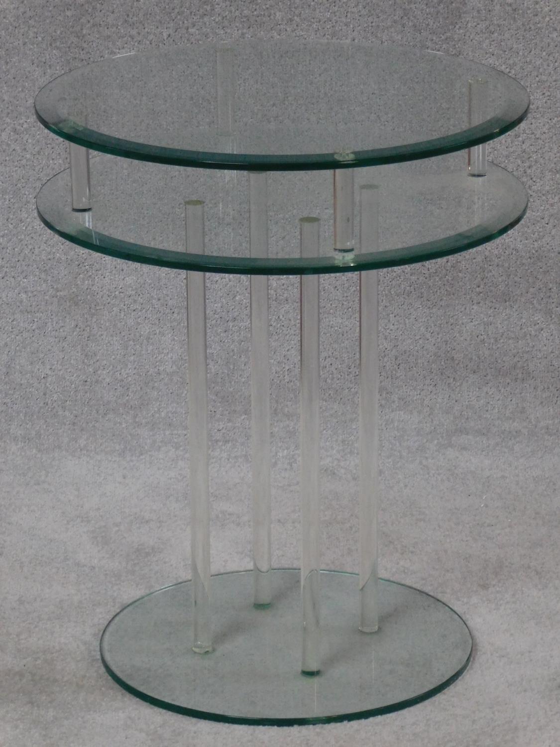A two tier pedestal occasional table with plate glass top and base on perspex supports. H.61 W.50