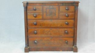 A Victorian figured mahogany chest of drawers with central hat drawer and an arrangement of seven