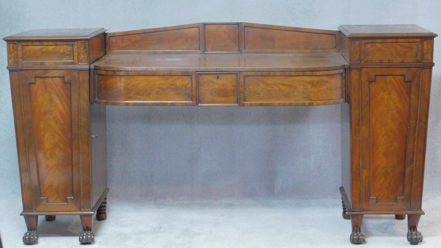 A Regency flame mahogany dwarf sideboard the sunken central section fitted with frieze drawer