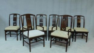 A set of eight Chinese hardwood dining chairs with carved splat backs and fitted squab cushions on