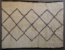 A Moroccan Berber tufted rug with repeating zigzags on an ivory ground. L.208x158cm