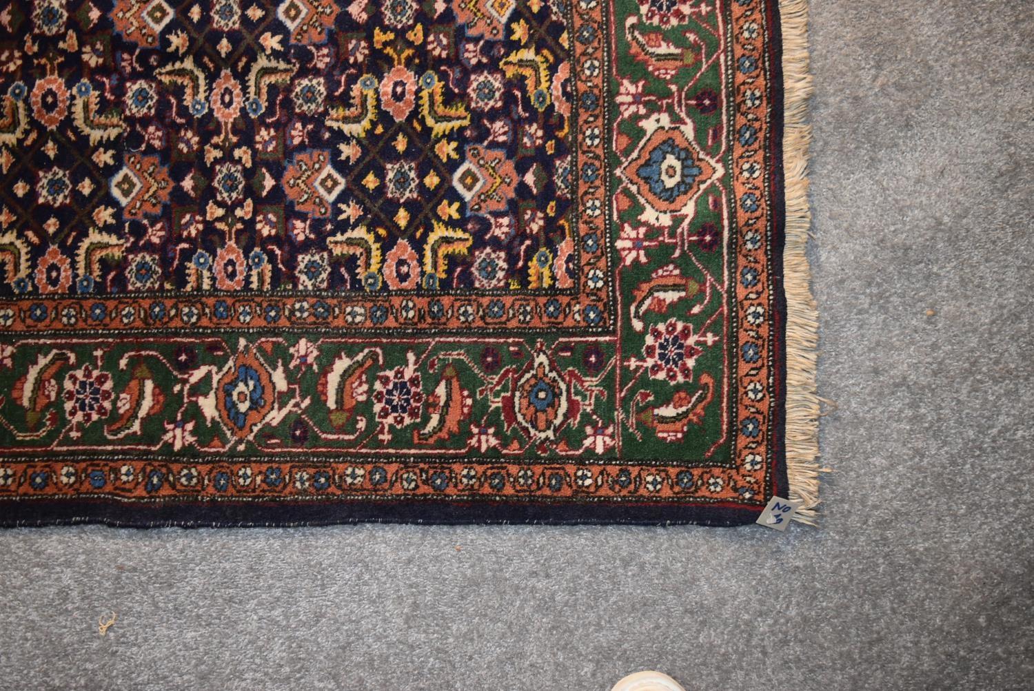 An Indian rug with repeating lozenge and foliate motifs on a deep sapphire ground contained within - Image 3 of 4