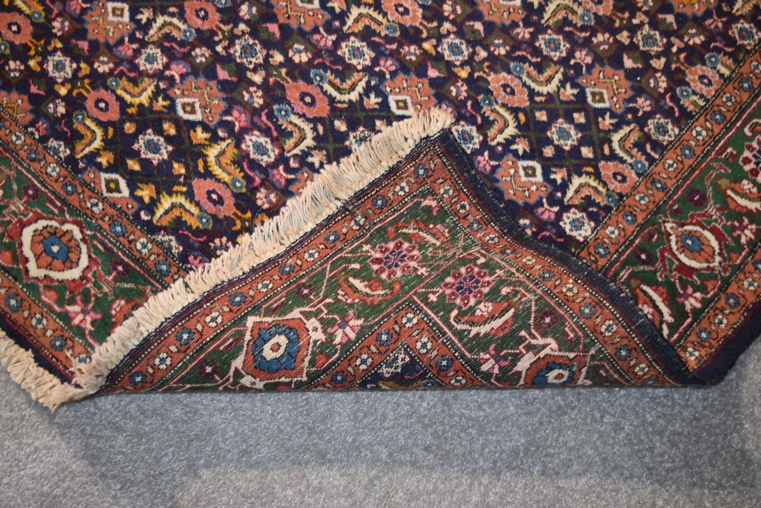 An Indian rug with repeating lozenge and foliate motifs on a deep sapphire ground contained within - Image 4 of 4