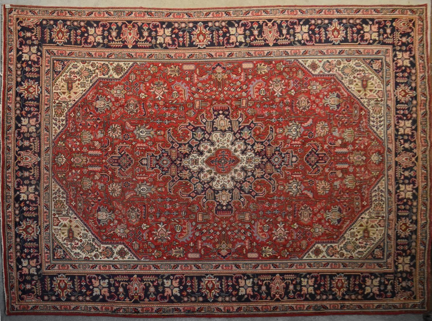 A Persian Tabriz carpet with floral central double pendant medallion surrounded by spandrels on a