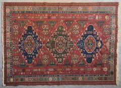 A Sumak Kilim with repeating pendant medallions on maroon ground surrounded by stylised floral and