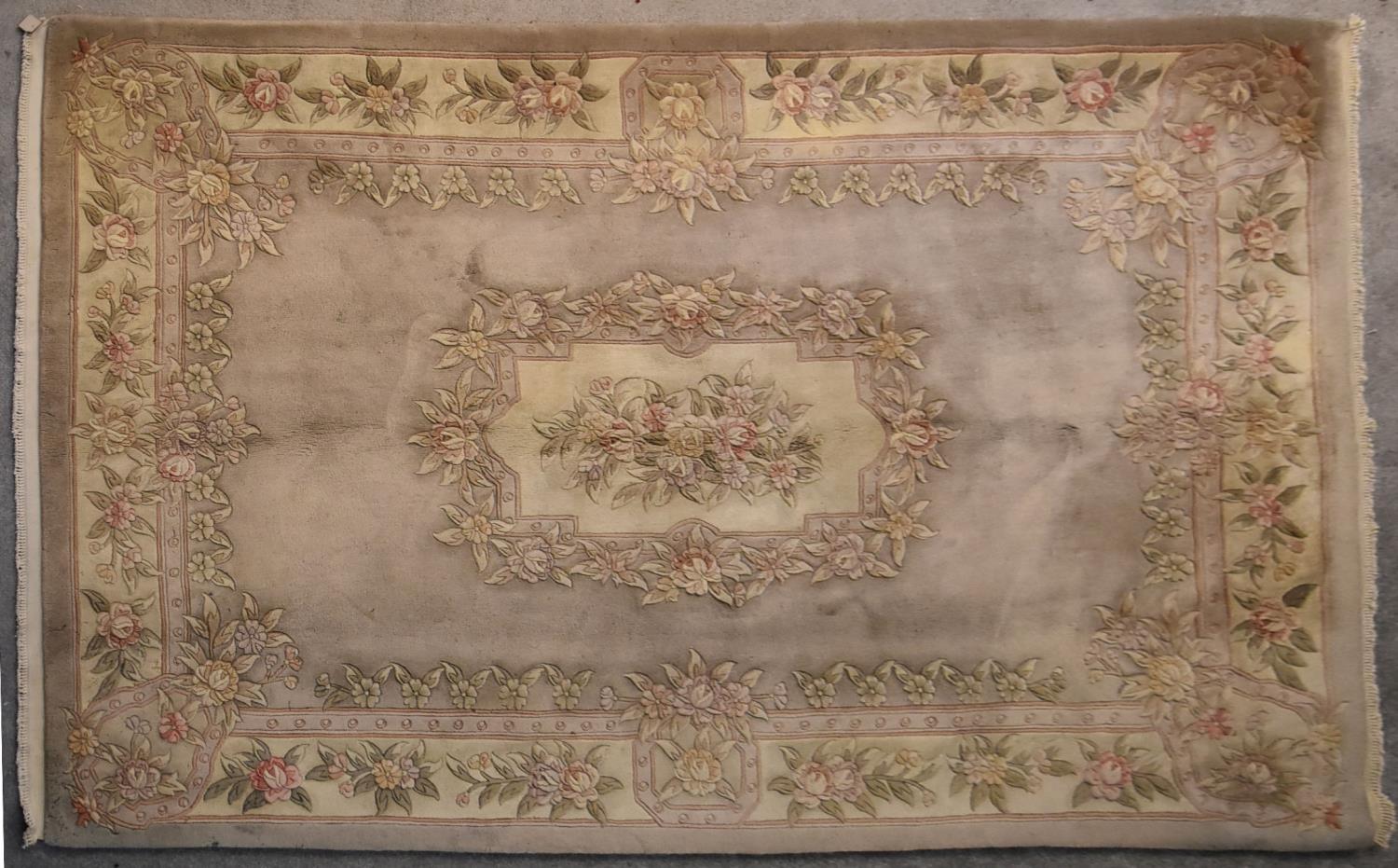 A Chinese woollen carpet with allover floral decoration on a mink ground.. L.284x184cm