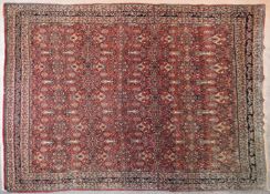 A Persian Bidjar carpet with repeating naturalistic petal motifs on a terracotta ground contained by