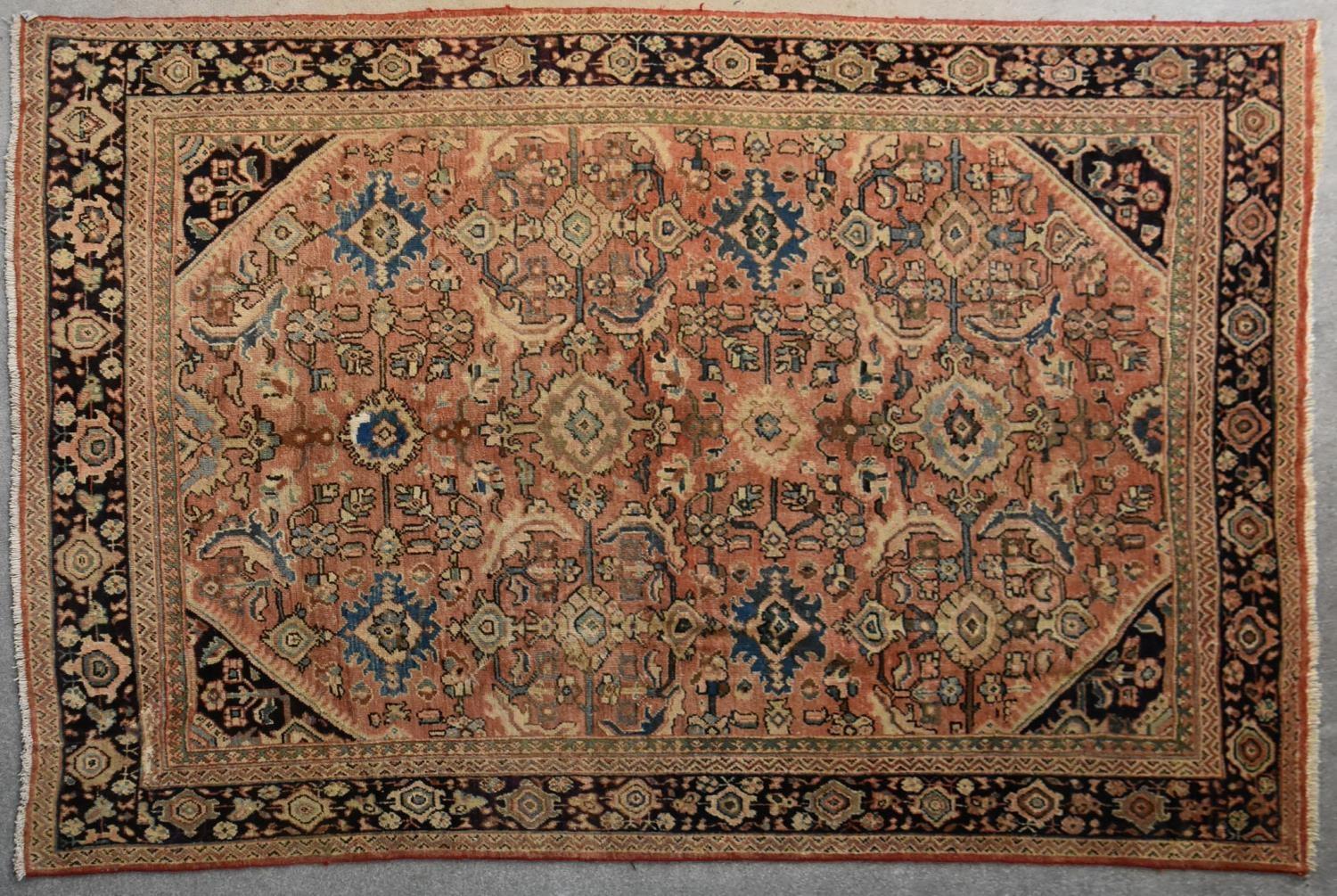 A Persian Mahal rug with repeating floral decoration and spandrels on a blush ground contained