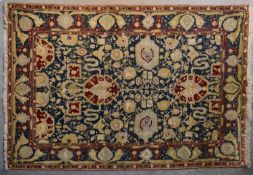 A pure wool Agra design carpet with lotus flower and palmette decoration on deep blue ground