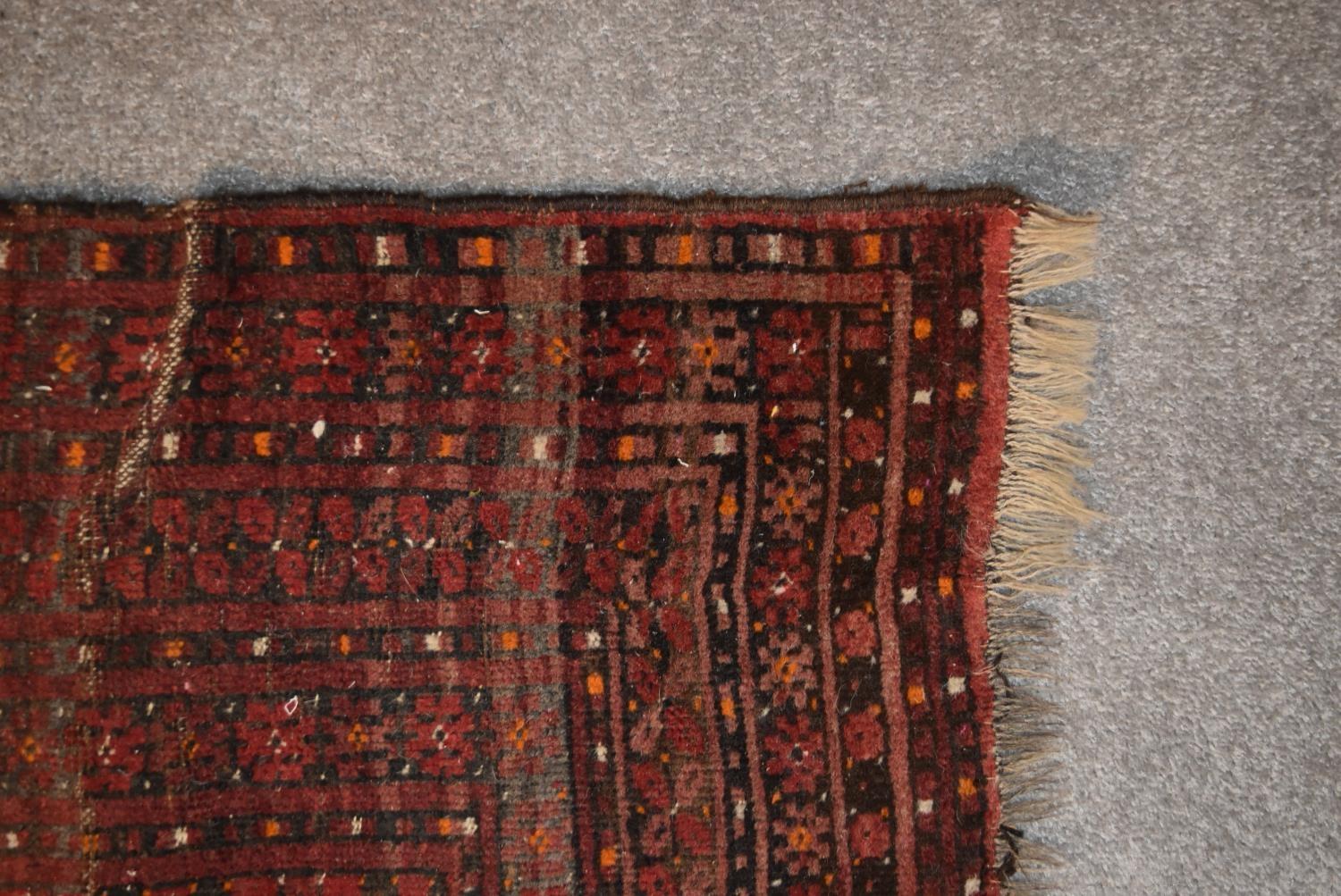 An Afghan Bokhara rug with repeating elephant's pad motifs on crimson ground within stylised multi - Image 3 of 4
