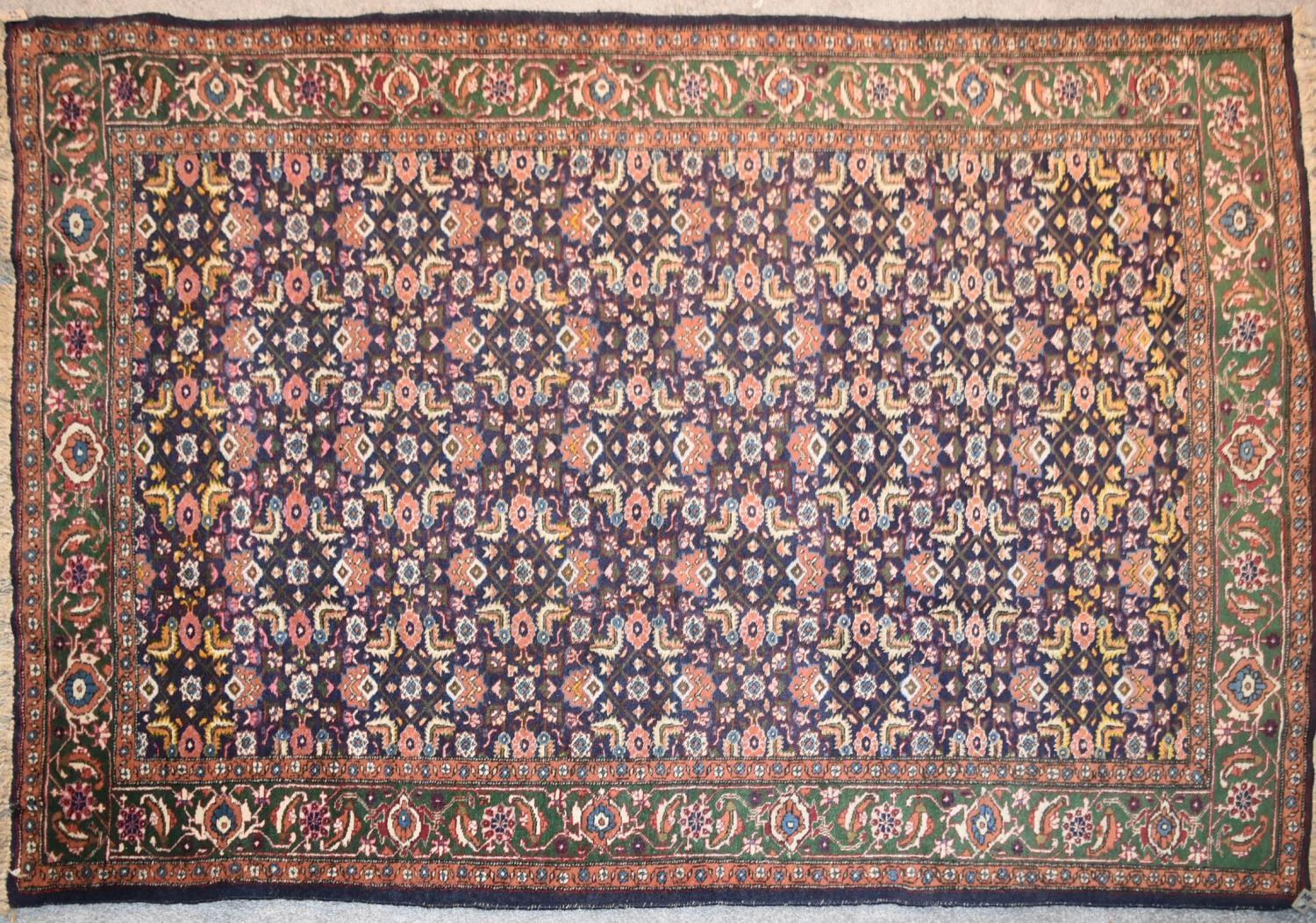 An Indian rug with repeating lozenge and foliate motifs on a deep sapphire ground contained within