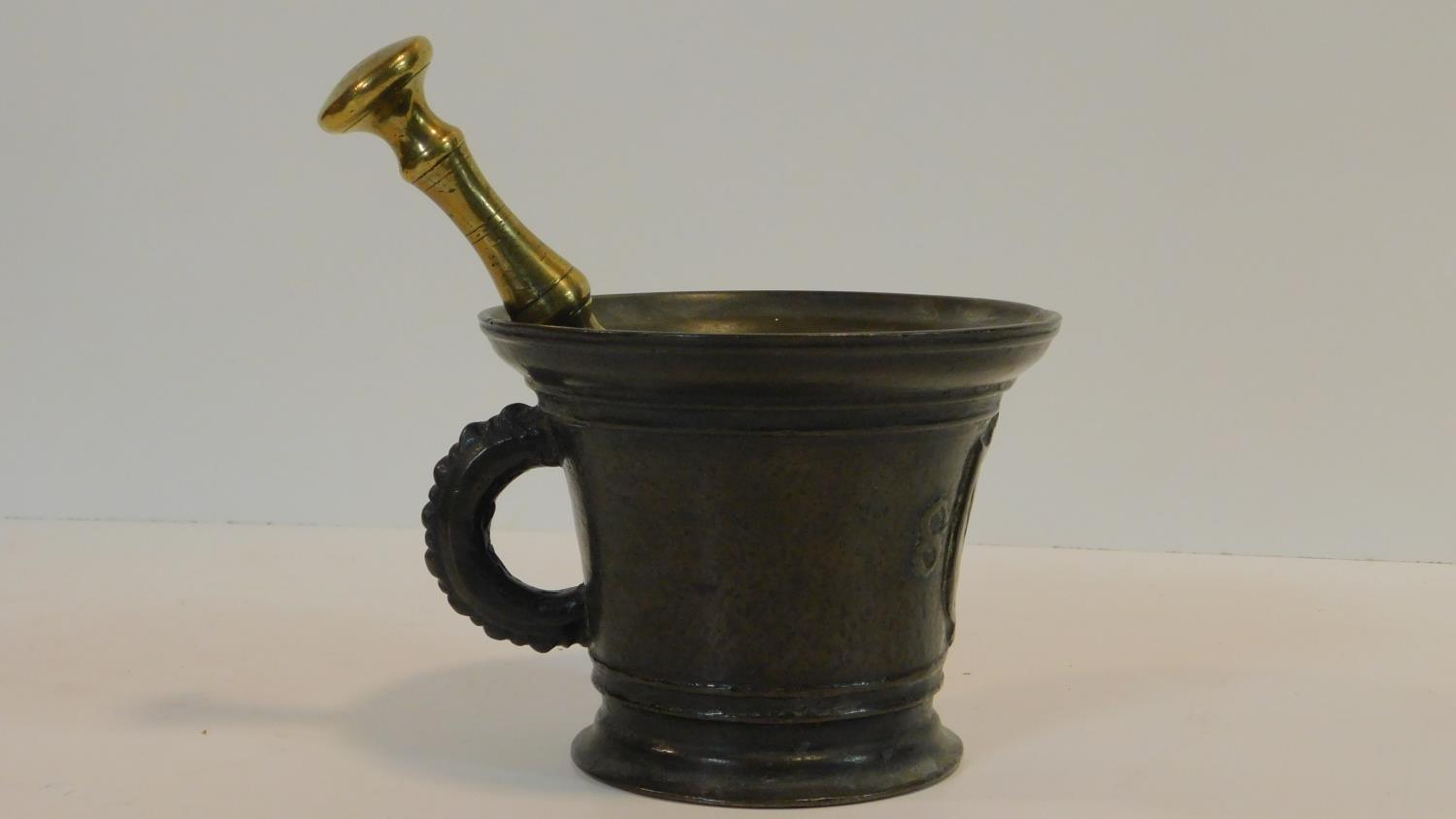 An antique bronze handled mortar and brass pestle. The handle has a textured design and the front of - Image 2 of 8