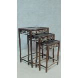 A nest of three Chinese hardwood occasional tables of graduating size with pierced frieze on