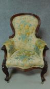 A Victorian mahogany framed armchair in floral upholstery on cabriole supports. H.107cm