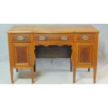 An early 20th century mahogany and satinwood inlaid desk with three frieze drawers over panel doors.