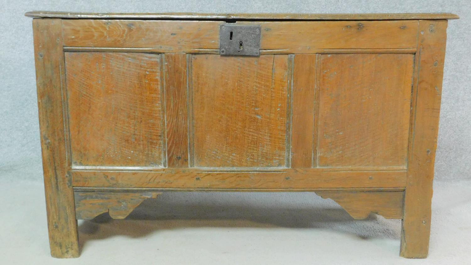 A Georgian country oak coffer with hinged top and panelled sides on block supports. H.73 W.122 D.