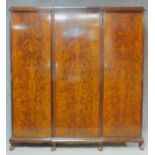 An early 20th century flame mahogany triple section compactum wardrobe with fitted interior and