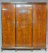 An early 20th century flame mahogany triple section compactum wardrobe with fitted interior and