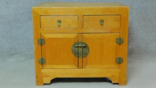 A Chinese side cabinet with two frieze drawers above panel doors on bracket feet. H.81 W.93 D.63cm