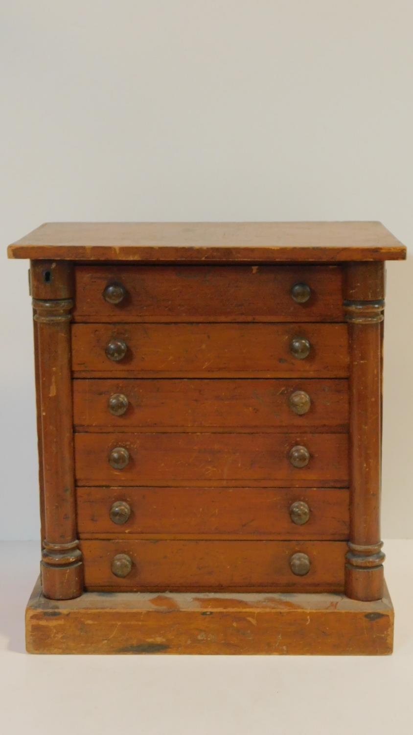 A 19th century miniature specimen Wellington chest of six drawers flanked by locking stiles in the