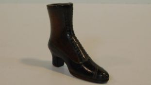 A Georgian wooden treen snuff box in the form of a heeled boot. With brass stud detailing for the