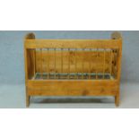 A European country style pitch pine cot with carved panels and hinged side. H.99 W.126 D.66cm