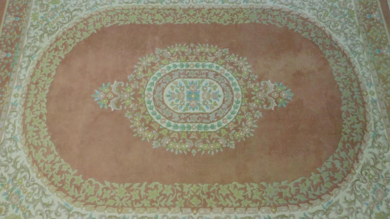 A large Persian carpet with central floral medallion on rouge ground and floral borders. 380x270cm - Image 2 of 4