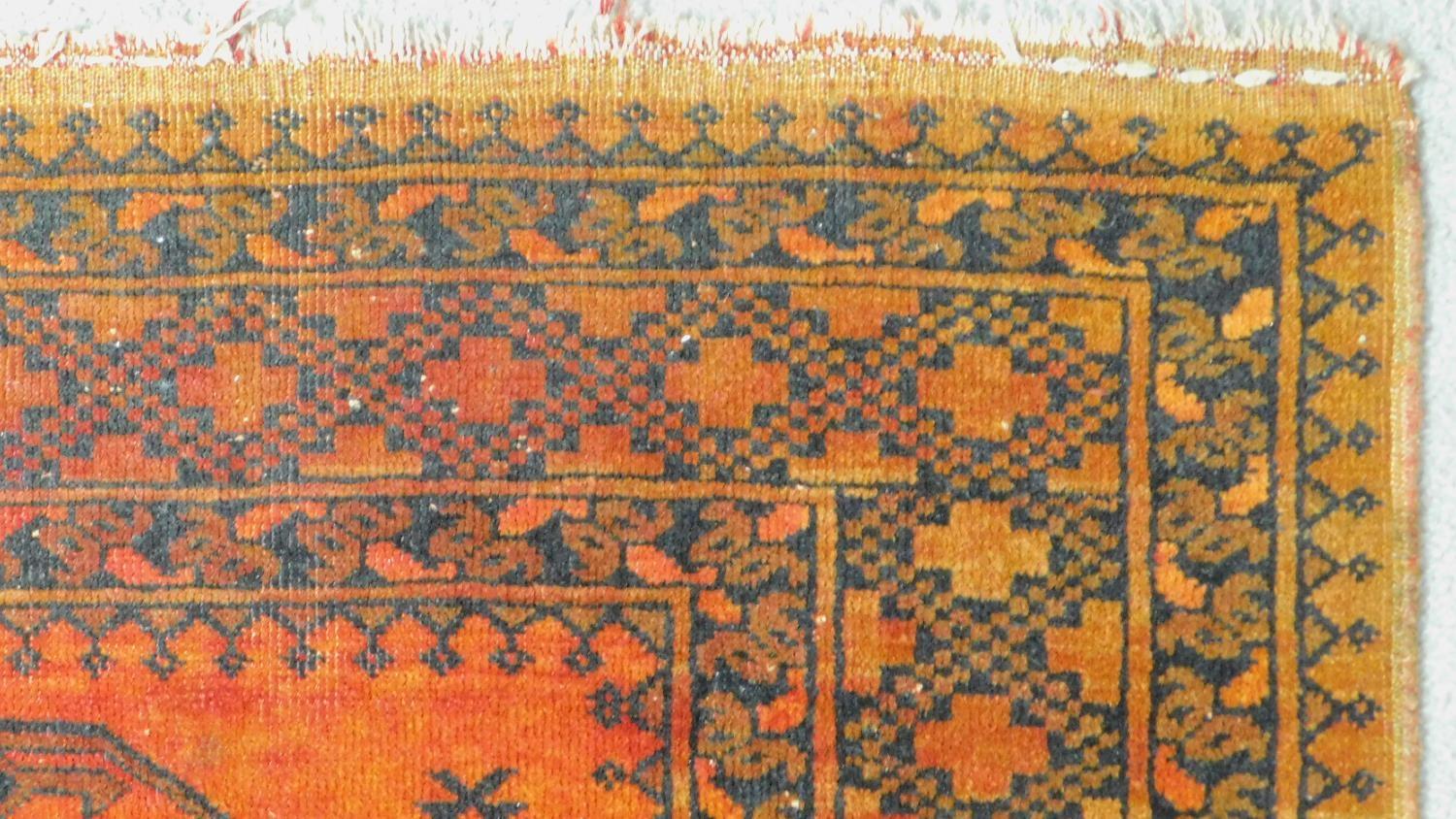 A Shirvan rug with repeating ersur gul medallions on terracotta ground within stylised geometric - Image 3 of 4