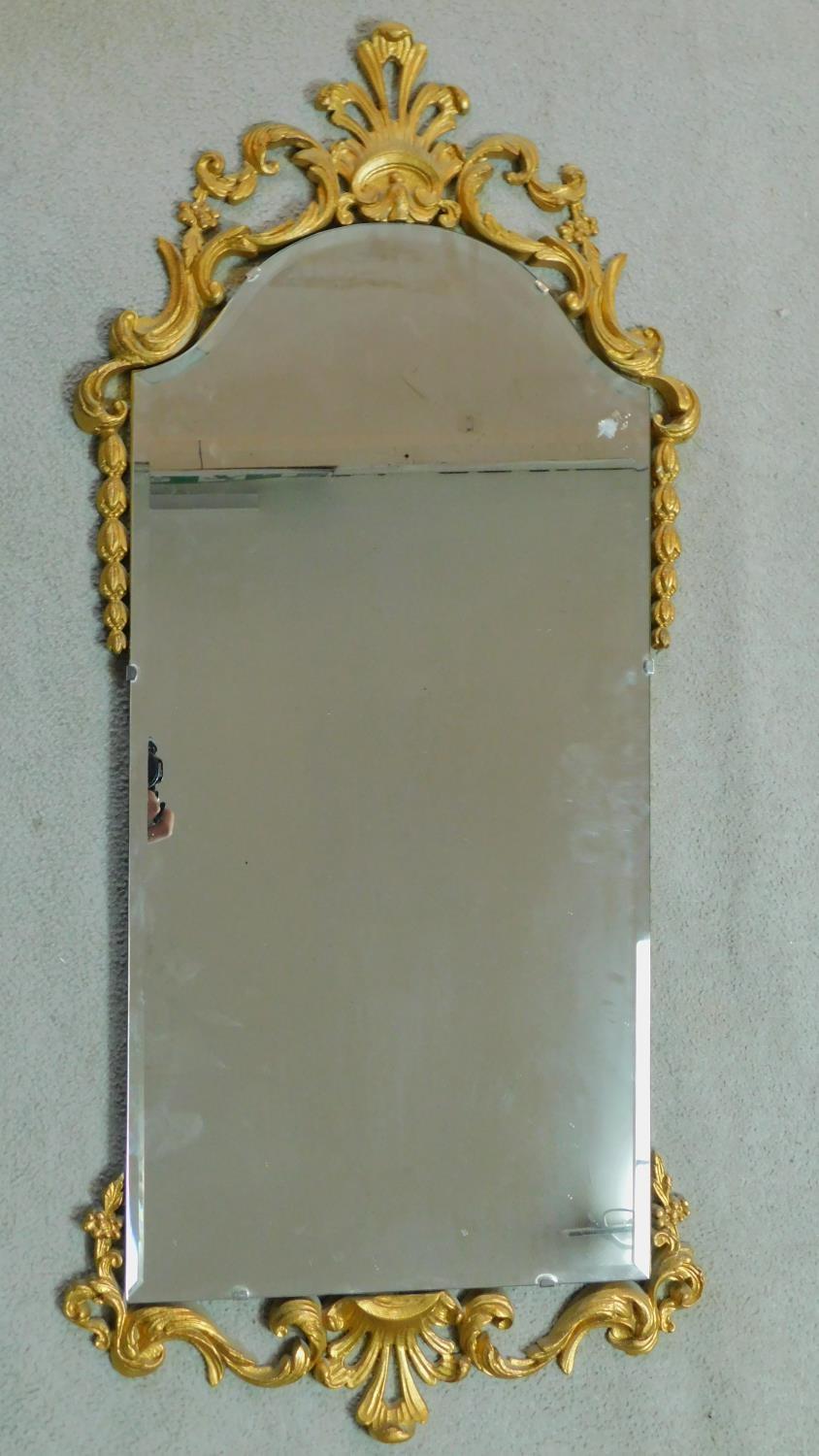 A mid century pier mirror with bevelled glass and gilt Rococo style frame. 47x104cm