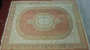 A large Persian carpet with central floral medallion on rouge ground and floral borders. 380x270cm