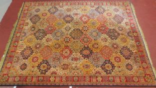 A large carpet with allover polychrome floral medallions across the field contained by stylised