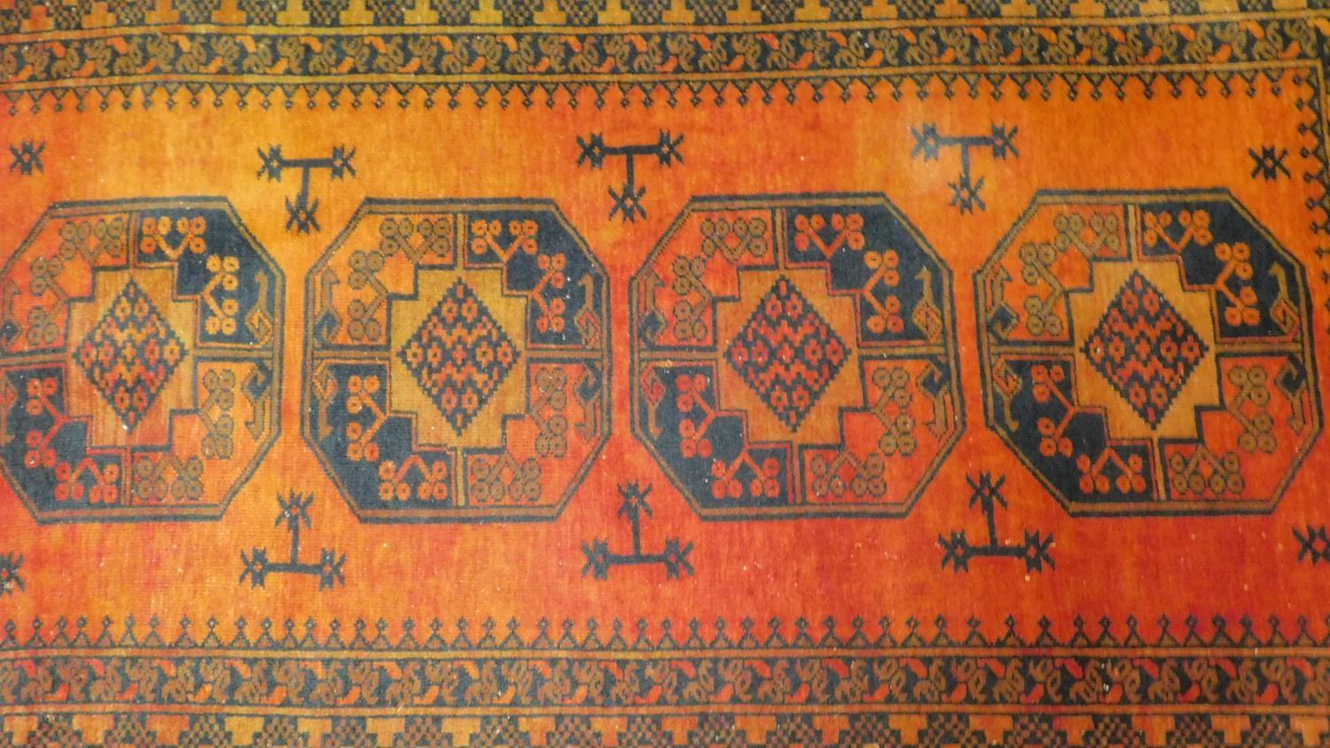 A Shirvan rug with repeating ersur gul medallions on terracotta ground within stylised geometric - Image 2 of 4