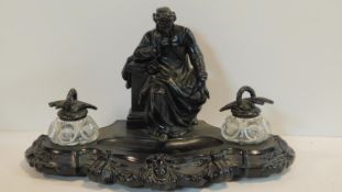 A 19th century painted spelter desk stand with a figure of Dante to its centre flanked by a pair