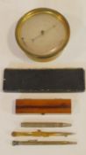 A brass cased barometer, a cased slide rule, a vintage cased thermometer, silver plated propelling