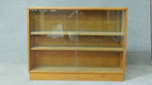 A mid century vintage teak dwarf bookcase with glass sliding doors. H.77 W.100 D.28cm