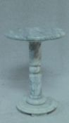 A white veined marble pedestal table on circular base. H.49 W.36cm