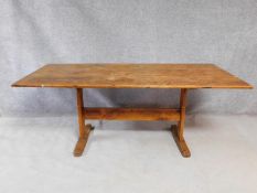 An antique fruitwood refectory table on stretchered trestle supports. H.76 W.190 D.89cm